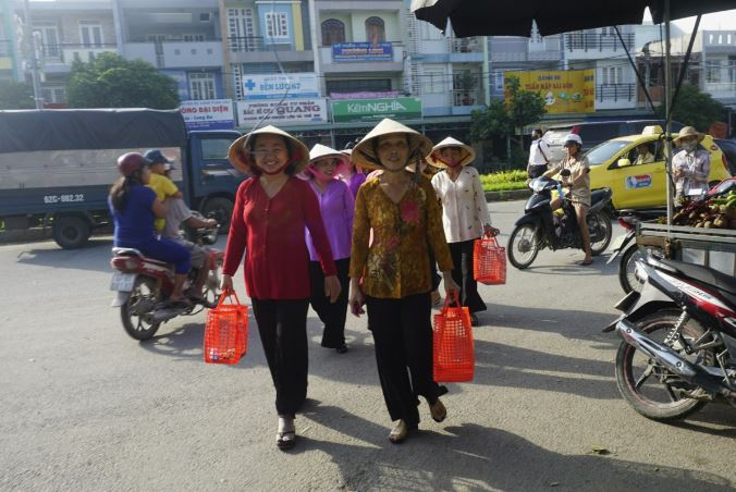 Phụ nữ xách giỏ đi chợ, thực hiện nếp sống xanh