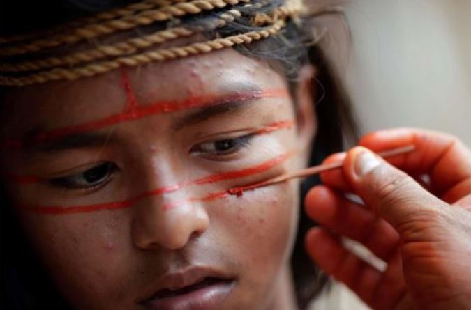 Các thành viên bộ lạc thổ dân Mura dùng sơn đỏ cam để hóa trang theo phong tục để gửi đến truyền thông quốc tế thông điệp bảo tồn rừng Amazon