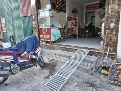 Cốt nền nhà dân cao hơn mặt đường nên người dân đã chế ra các loại thang để vào nhà tại phố Minh Khai. Ảnh: Thùy Anh