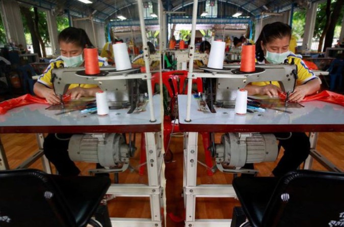 Phụ nữ may đồ PPE cho các nhà sư tại một nhà máy dệt ở tỉnh Rayong, Thái Lan