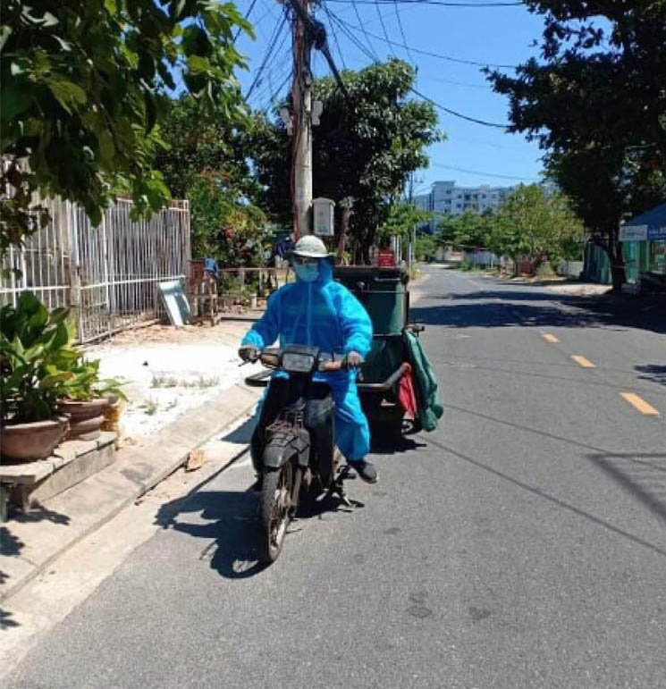 Công nhân Xí nghiệp môi trường quận Sơn Trà mặc đồ bảo hộ đi lấy rác ở các khu dân cư