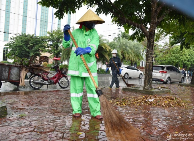 Công nhân môi trường TP. Vinh dầm mưa quét dọn rác, khơi thông cống-1