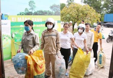 Công nhân Nhà máy Xi măng Lam Thạch (Công ty CP Xi măng và Xây dựng Quảng Ninh) và người dân phường Phương Nam (TP Uông Bí) xếp hàng để gửi rác cho mô hình “Ngân hàng rác - gửi rác, rút tiền”.